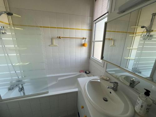 ein Badezimmer mit einem Waschbecken, einer Badewanne und einem Spiegel in der Unterkunft Appartement Wimereux, 2 pièces, 4 personnes - FR-1-675-16 in Wimereux
