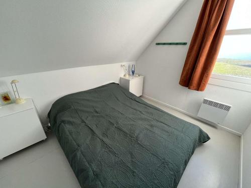 ein Schlafzimmer mit einem grünen Bett und einem Fenster in der Unterkunft Appartement Wimereux, 2 pièces, 4 personnes - FR-1-675-16 in Wimereux