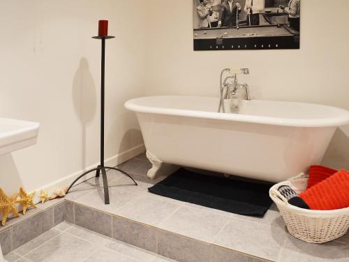 a white bath tub sitting in a bathroom at Lilac Barn in Newton Reigny