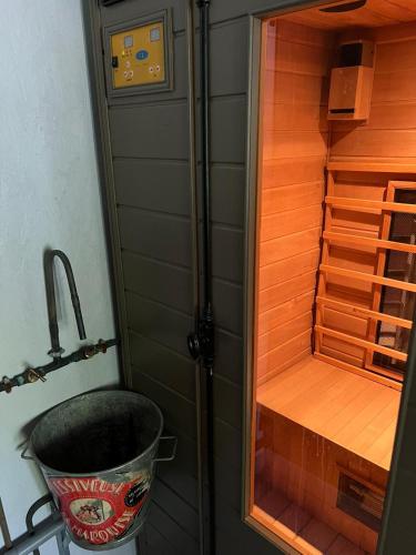 a shower with a bucket in a sauna at Les chambres de Pauline avec spa et climatisation parking moto garage vélo in Albertville
