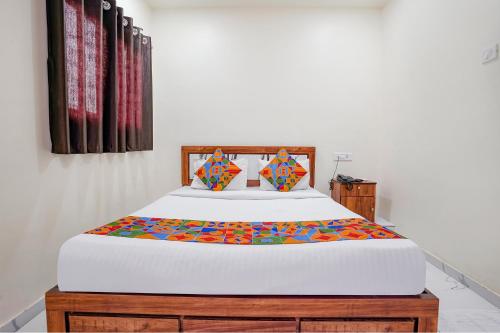 a bedroom with a large bed with a colorful comforter at Via Chaitanya Inn in Pune