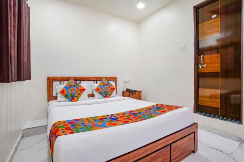 a bedroom with a bed with a colorful blanket on it at Via Chaitanya Inn in Pune