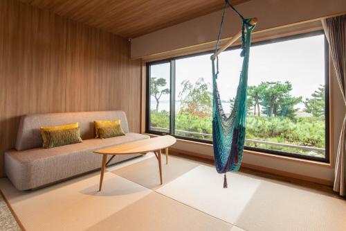 a living room with a hammock hanging from a window at Matsushima Ichinobo in Matsushima