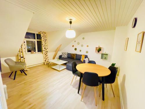 a living room with a couch and a table and chairs at aday - Cozy central 1 bedroom apartment in Frederikshavn