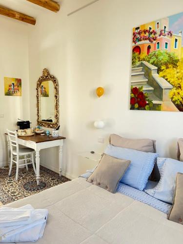 sypialnia z łóżkiem, stołem i lustrem w obiekcie Suite Battisti 7 w mieście Lecce