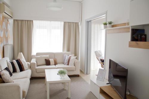 a living room with a couch and a tv at ΗΒΗ MINI HOME in Chalkida