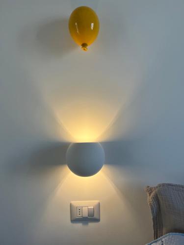 a light fixture on a wall next to a lightswitch at Suite Battisti 7 in Lecce