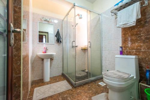 a bathroom with a shower and a toilet and a sink at Tropical themed 3BR and DSQ Apartment in Nairobi