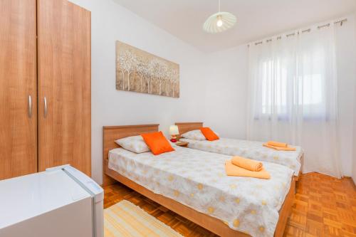 1 dormitorio con 2 camas con almohadas de color naranja en Rooms Ivo, en Dubrovnik