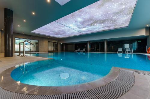 a large swimming pool in a hotel with a star ceiling at FACTORY RESORT wellness & spa in Kołobrzeg