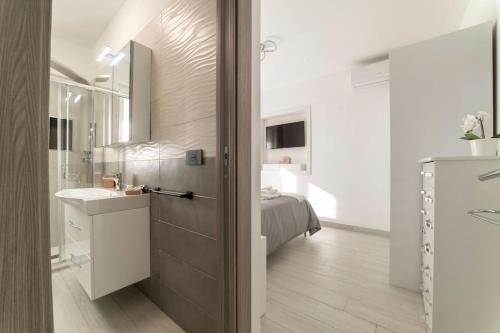 baño con lavabo y 1 cama en una habitación en Appartamento Emma con Piscina - Vista Mare"Tenuta Croce" en Salerno