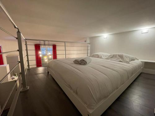 sypialnia z dużym białym łóżkiem z czerwonym oknem w obiekcie Hyper Centre Orléans : Magnifique appartement w Orleanie