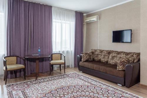 a living room with a couch and a table at Azamat Hotel in Astana