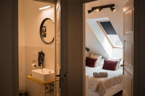 a bathroom with a sink and a bed in a room at Válibor Vinotéka Apartman in Badacsonytomaj