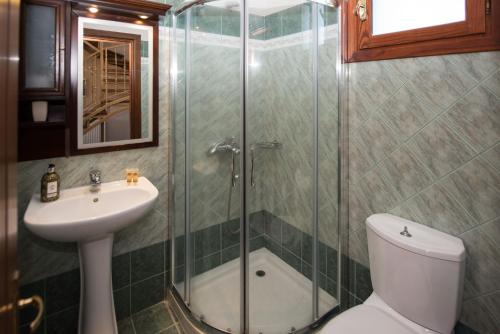 y baño con ducha, aseo y lavamanos. en Erikousa Villas by CorfuEscapes, en Ereikoússa