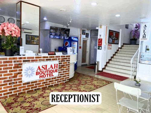 an asian boutique hotel with a reception desk and stairs at ASLAH BOUTIQUE HOTEL in Kota Bharu