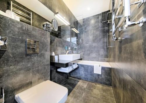 a bathroom with a toilet and a sink and a tub at Bayjonn Boutique Hotel in Sopot