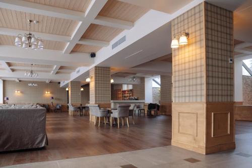 a large lobby with a dining area and tables at Apricot Aghveran Resort in Agveran