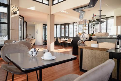 Domicil Hotel Bonn في بون: غرفة طعام ومطبخ مع طاولة وكراسي
