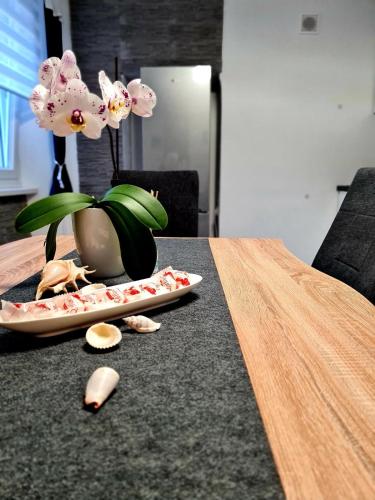 a table with a plate with a vase with flowers at Freedom house in Piran