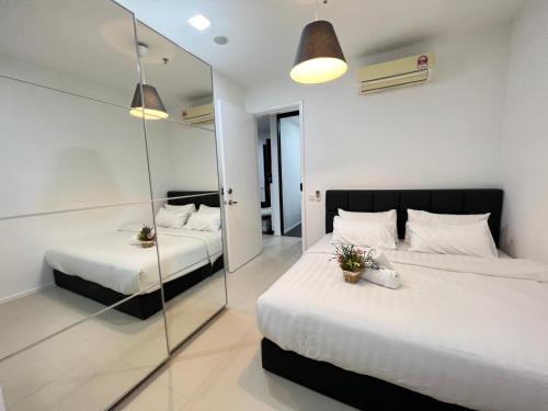 a bedroom with two beds and a mirror at ARCORIS, MONT KIARA by MK HOME in Kuala Lumpur