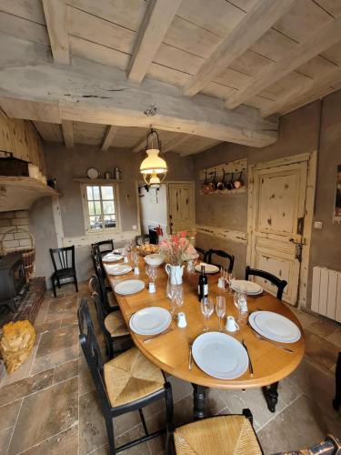 une grande salle à manger avec une grande table en bois dans l'établissement Gîte de charme, salle de jeux, proche plage du débarquement, à Sainte-Mère-Église