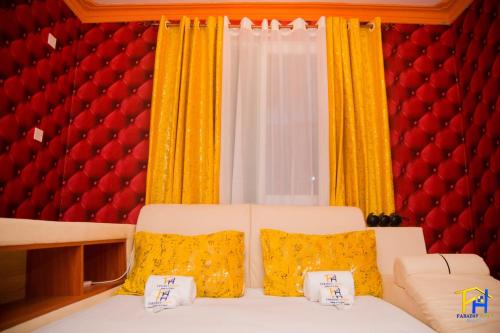 a living room with a white couch and yellow curtains at Lux Suites Mtwapa Luxury Apartments in Mtwapa