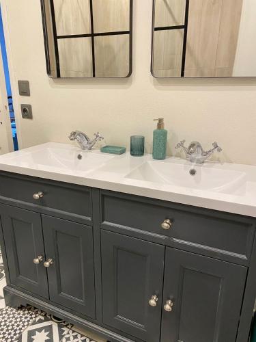 La salle de bains est pourvue d'une coiffeuse noire et d'un lavabo blanc. dans l'établissement Le Petit Cinq Ruffe, à Listrac-de-Durèze