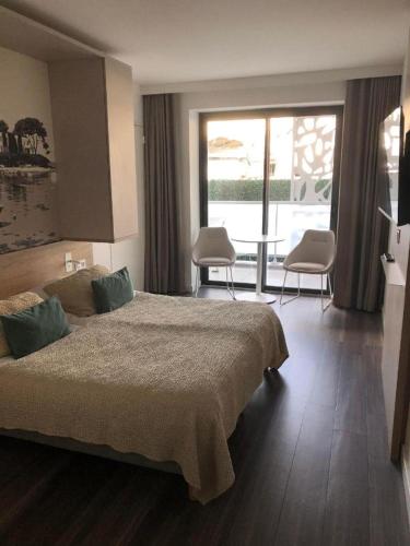a hotel room with a bed and a table and chairs at Lagrange Apart'Hôtel Antibes Olympie in Antibes