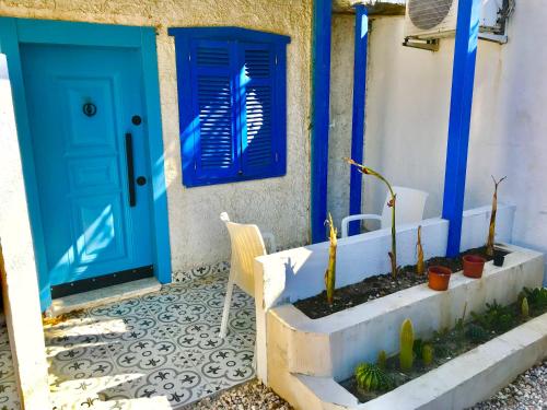 a blue door and some plants in front of a house at Hotel Barba in Urla