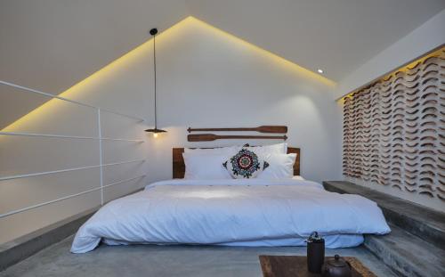 1 dormitorio con 1 cama grande y pared grande en Barbados Cherry Villa en Hoi An