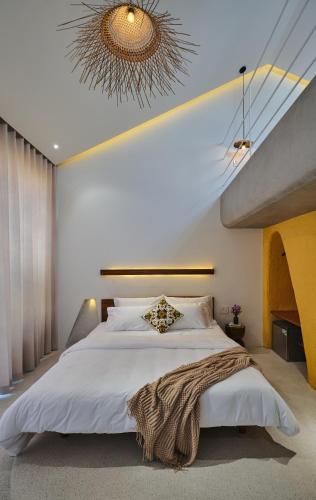 a bedroom with a large bed and a chandelier at Barbados Cherry Villa in Hoi An