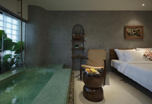a bedroom with a tub and a bed and a bedroom with a bed at Barbados Cherry Villa in Hoi An
