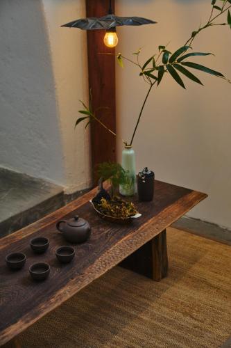 a wooden table with black bowls and a plant on it at Barbados Cherry Villa in Hoi An