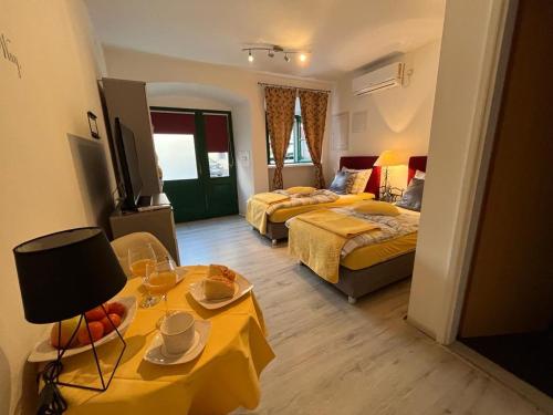 Cette chambre comprend 2 lits et une table avec de la nourriture. dans l'établissement Titius Apartment, à Skradin