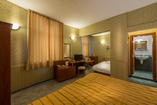 ein Hotelzimmer mit einem Bett und einem Waschbecken in der Unterkunft Family Hotel Chiplakoff in Burgas City