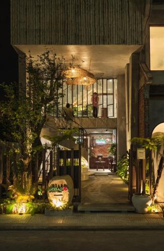 a house with a staircase and a person sitting on a balcony at Barbados Cherry Villa in Hoi An