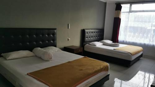 a bedroom with two beds and a window at dgraciasguezt in Pangandaran
