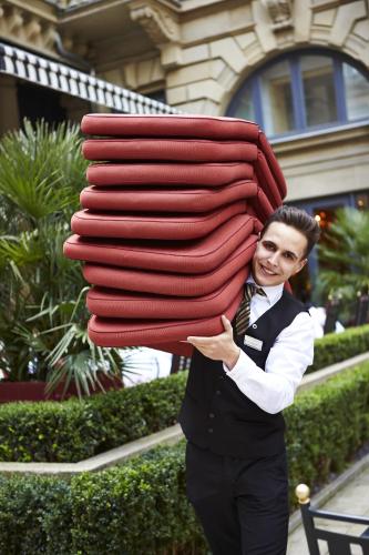 a man is holding a large stack of blankets at Steigenberger Icon Frankfurter Hof in Frankfurt/Main