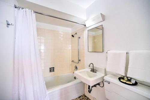 y baño blanco con lavabo y bañera. en Bright and Airy Apartment about 10 Mi to Dive Land Park!, en Gadsden