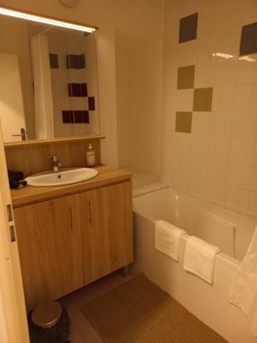 La salle de bains est pourvue d'un lavabo, d'une baignoire et d'un miroir. dans l'établissement Apparteo Perpignan, à Perpignan