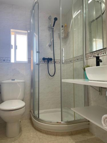 y baño con ducha, aseo y lavamanos. en Apartamento Excelentes vistas a la Ria, Wifi y Parking, en San Vicente de la Barquera