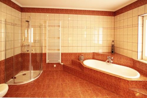 a bathroom with a tub and a shower and a sink at Ferienhaus Jule in Pudagla