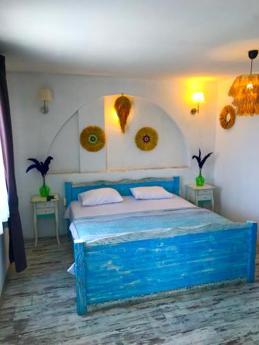 a blue bed in a room with two tables at Hotel Barba in Urla