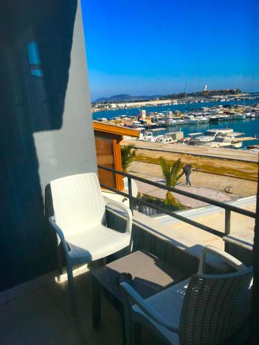 a balcony with two chairs and a view of a marina at Hotel Barba in Urla