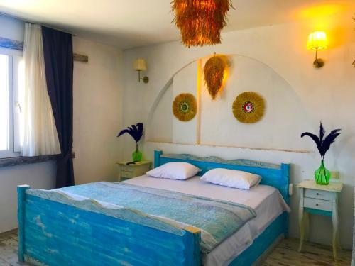 a bedroom with a blue bed with two pillows at Hotel Barba in Urla