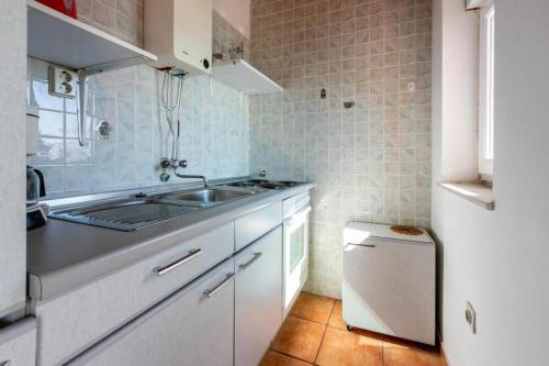 une petite cuisine avec un évier et une cuisinière dans l'établissement Apartments Vera, à Supetarska Draga
