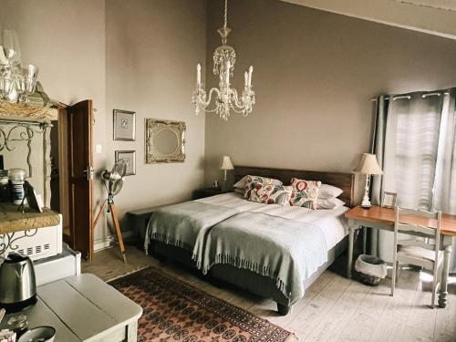 a bedroom with a bed and a table and a chandelier at 35 on Basil in Caledon