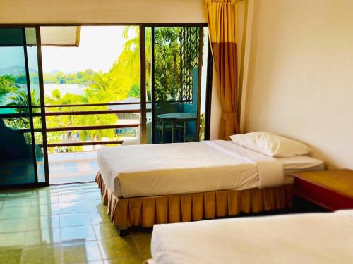 Habitación de hotel con 2 camas y balcón en Duenshine Resort, en Kanchanaburi