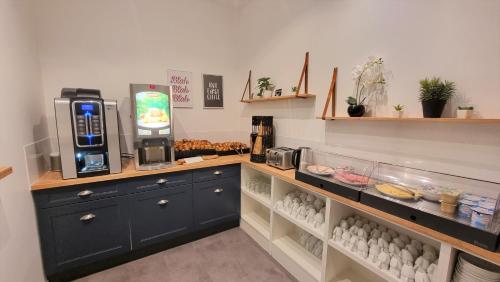 a kitchen with a counter with eggs and a coffee maker at Oskar Hotel in Annemasse
